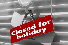 Sign saying "Closed for holiday" on a glass door with a white, closed venetian blind. It can be used for business concepts or backgrounds.